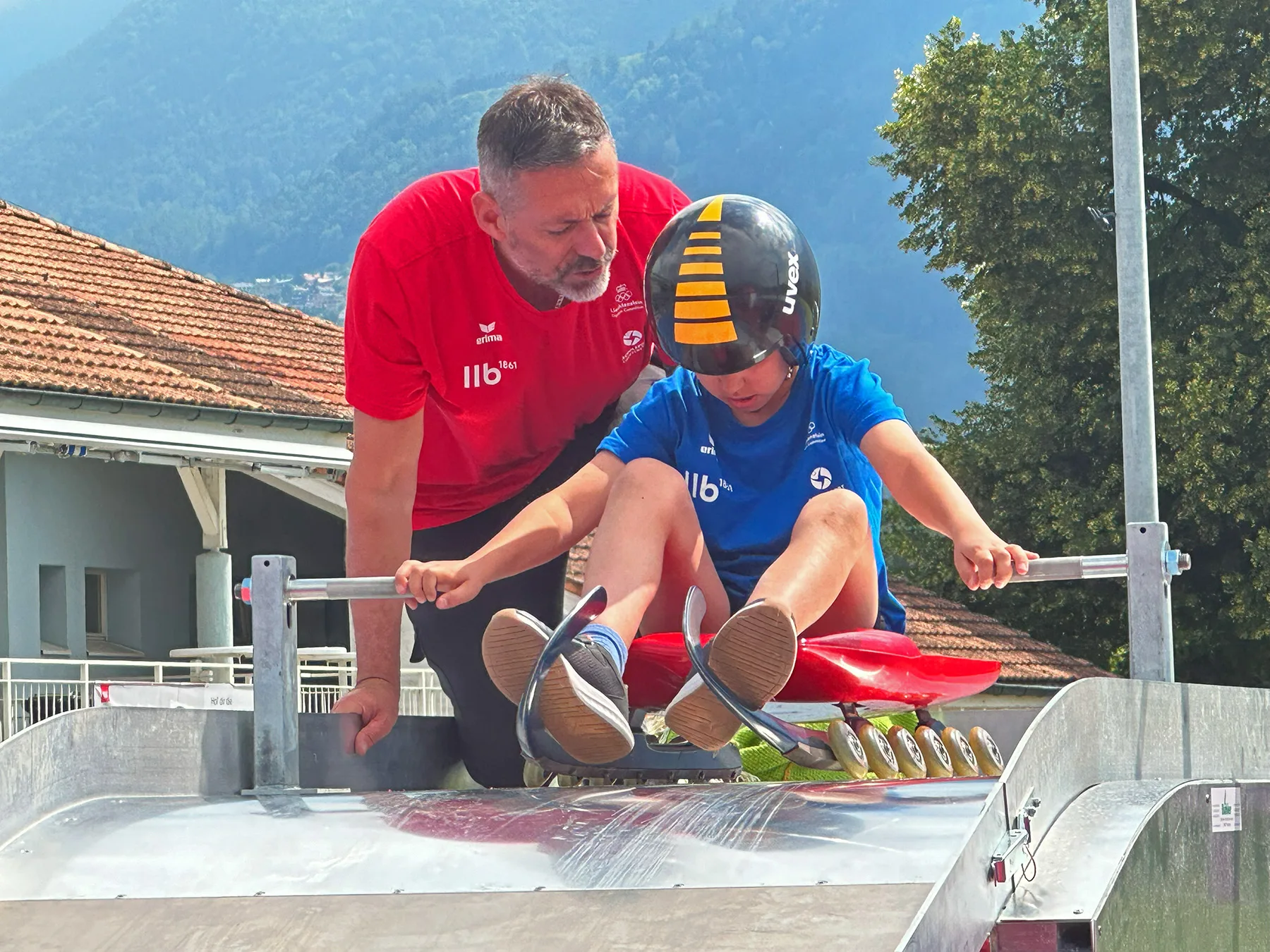 Philipp Beck instruiert ein Jugendlicher Rodler beim Olympic Day i