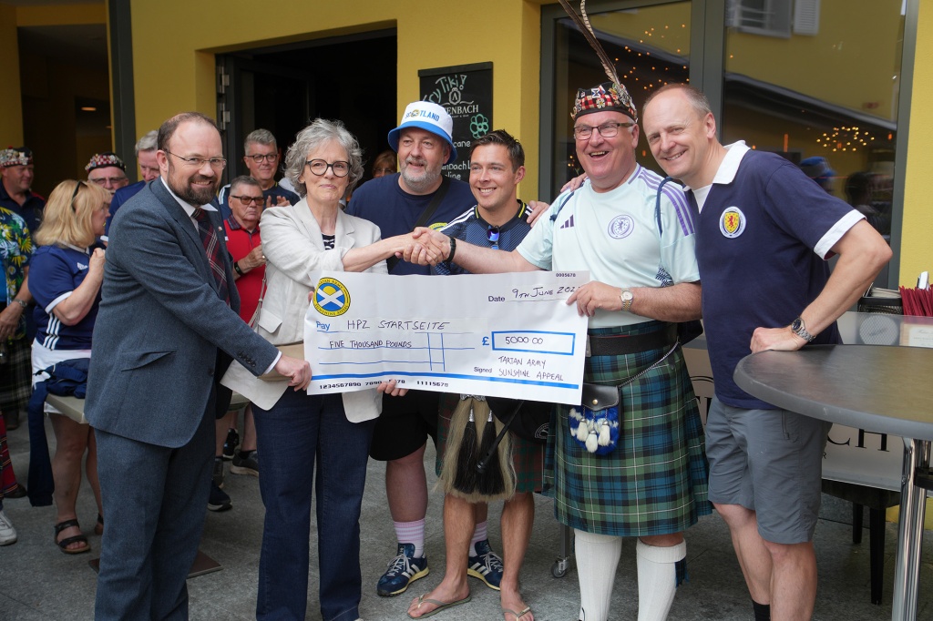 Botschafter James Squire, Carol Ritter, Niel Forbs und Vertreter der Tartan Army bei der Scheckübergabe